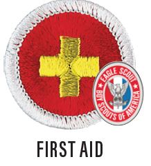 Image of a First Aid merit badge. The badge is red with white border and a yellow cross in the middle.